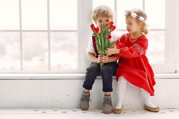 Elegantes niños pequeños con ramo de tulipanes