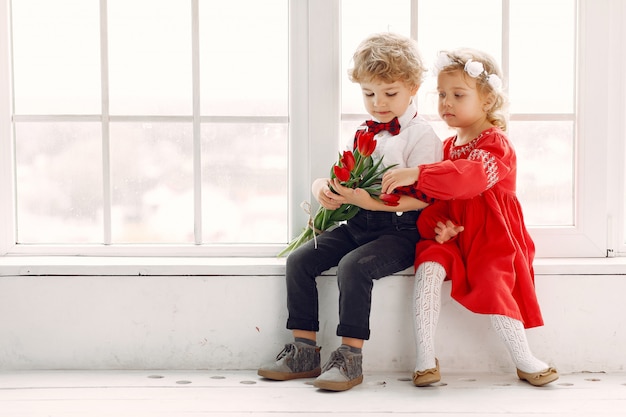 Elegantes niños pequeños con ramo de tulipanes