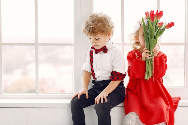 Elegantes niños pequeños con ramo de tulipanes