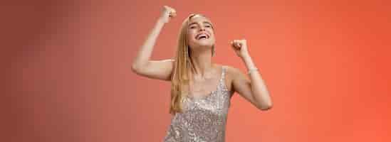 Foto gratuita emocionada despreocupada feliz elegante mujer rubia europea divirtiéndose bailando sonriendo ampliamente riendo