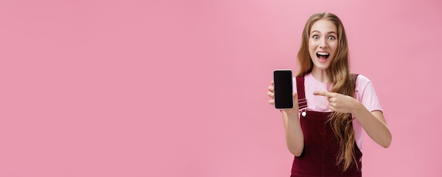 Foto gratuita emocionada y emocionada joven adolescente con mono y camiseta sonriendo asombrada llena de felicidad