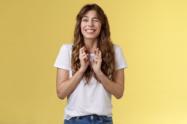 Emocionada feliz alegre optimista chica asoma nerviosamente esperando resultados mirar un ojo cámara hopefu ...