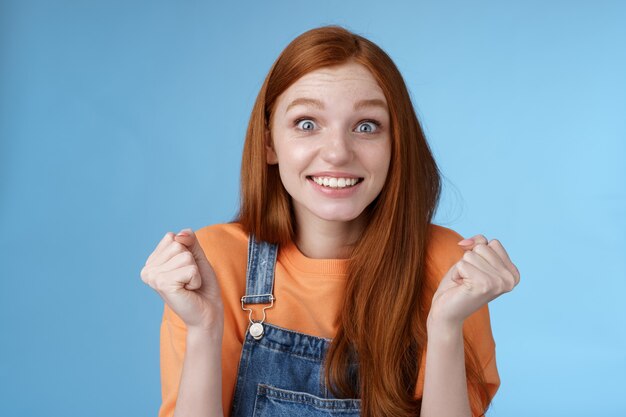 Emocionada joven compañera de trabajo feliz recibe una excelente oportunidad triunfando alegremente sonriendo apretando los puños de la cámara celebrando el éxito de la victoria regocijándose con las fantásticas buenas noticias sorprendidas. Copia espacio