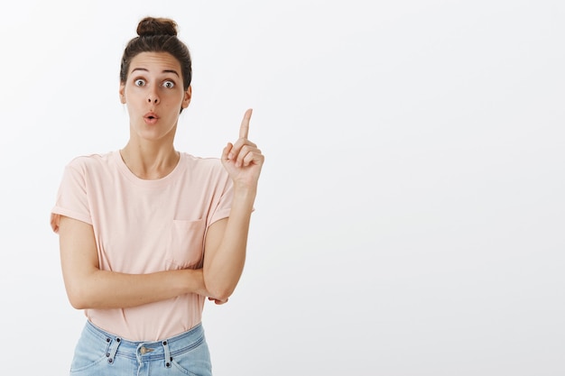 Foto gratuita emocionada joven elegante posando contra la pared blanca