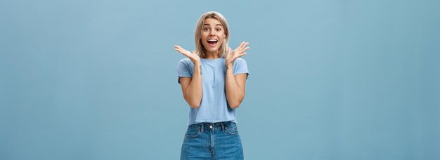 Emocionada mujer feliz entusiasta en camiseta de moda y pantalones cortos aplaudiendo de asombro sonriendo