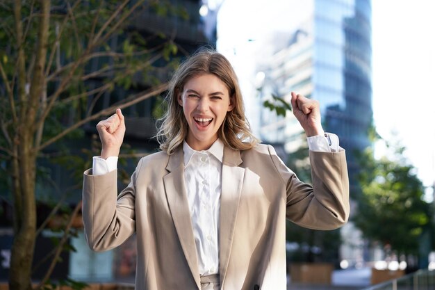 Emocionada mujer de negocios grita y celebra levanta las manos hace un gesto de hurra celebra la victoria a