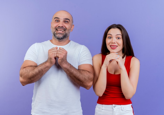 Emocionada pareja adulta mirando manteniendo las manos juntas y suplicando algo