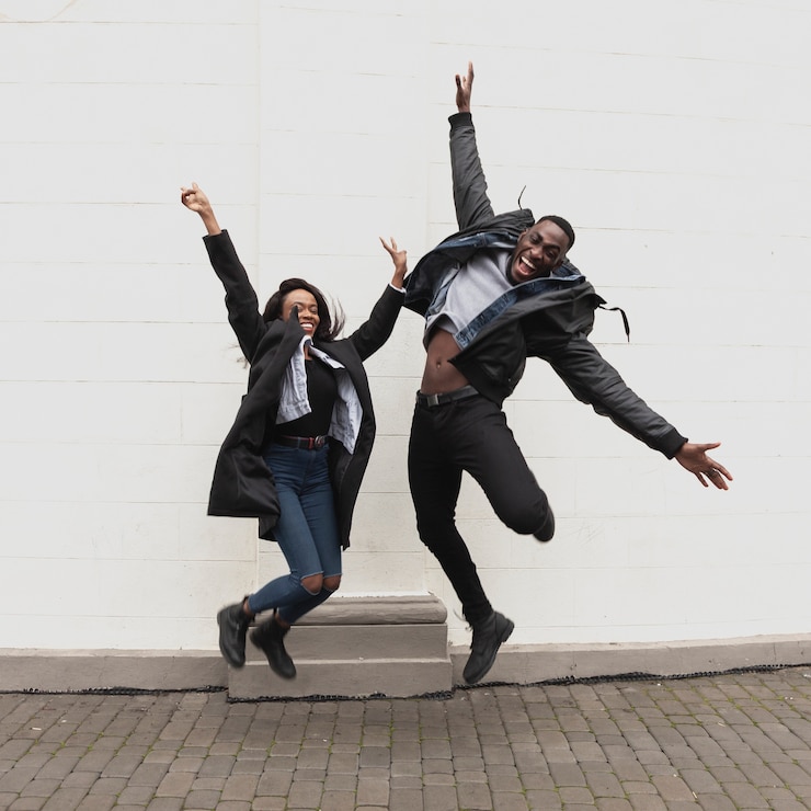 Foto gratuito emocionada pareja afroamericana saltando tiro completo