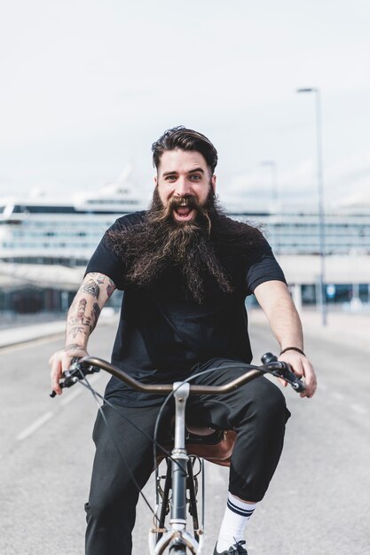 Emocionado barbudo joven disfrutando de la bicicleta