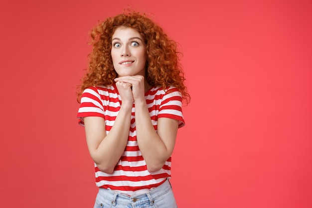 Emocionado emocionado joven impulsivo apuesto pelirrojo femenino mirada cámara expreso deseo aspiración sonriendo loco agarrar la mano barbilla presionada mantenerse unida quiere tener algo con ganas de comer.