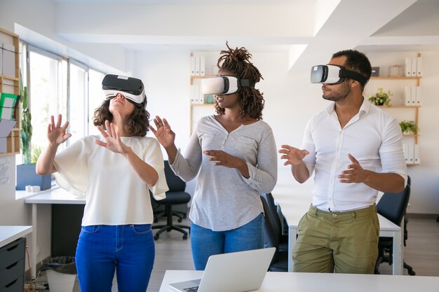 Emocionado equipo de tres simuladores de realidad virtual de prueba