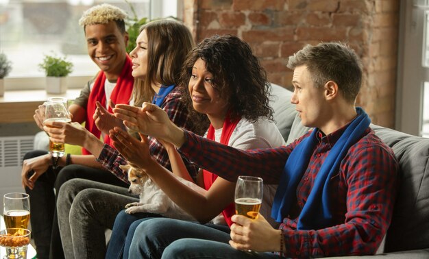 Emocionado grupo de personas viendo deporte partido en casa