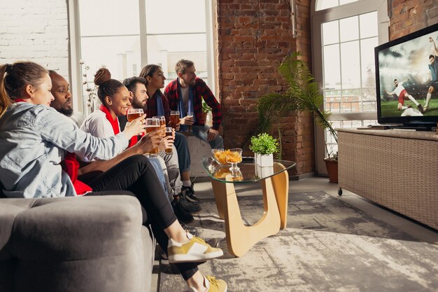 Emocionado grupo de personas viendo fútbol, partido de fútbol en casa.