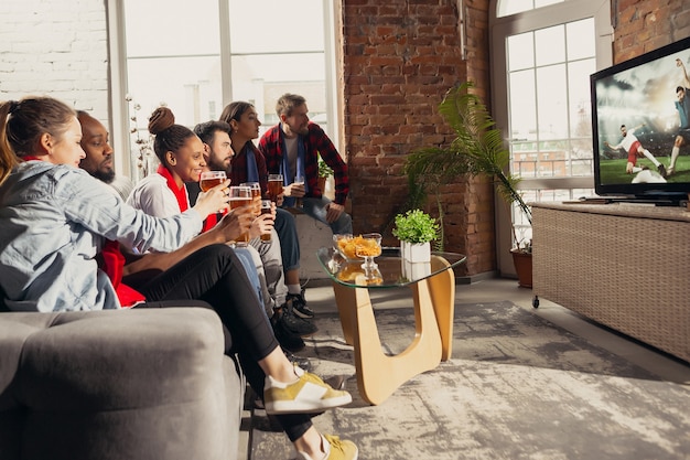 Emocionado grupo de personas viendo fútbol, partido de fútbol en casa.