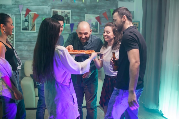 Foto gratuita emocionado joven y mujer sobre pizza en una fiesta con buena música.