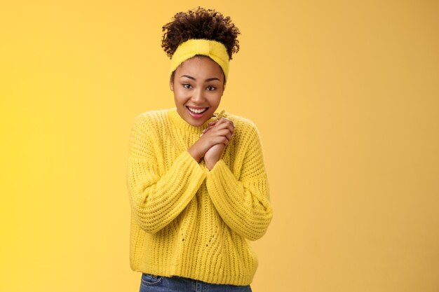 Emocionado linda encantadora niña sonriente afroamericana cruzar los dedos buena suerte presionar las manos juntas sonriendo mirar con suerte cámara rezando buena suerte sueño hecho realidad creer recibir noticias positivas