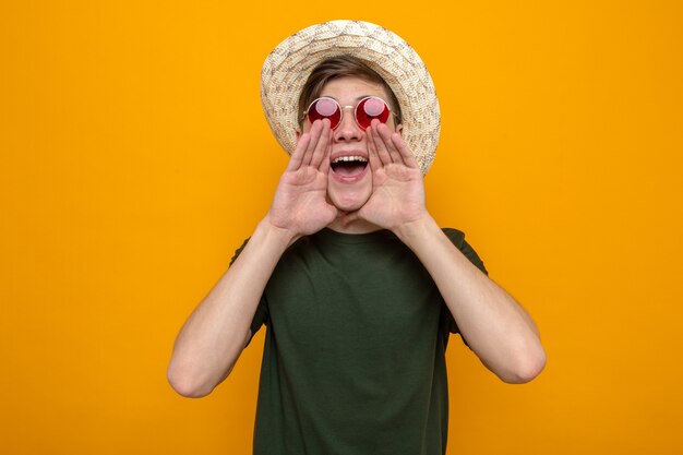 Emocionado llamando a alguien joven guapo con sombrero con gafas