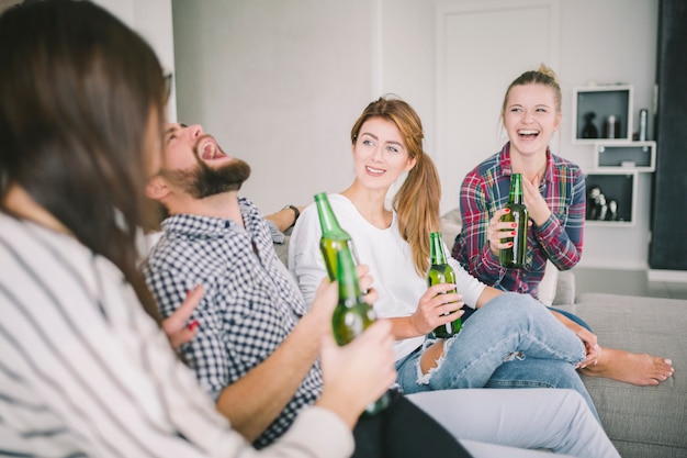 Emocionados jóvenes amigos bebiendo cerveza