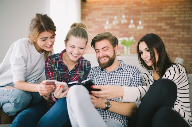 Emocionados jóvenes amigos con teléfonos inteligentes se divierten