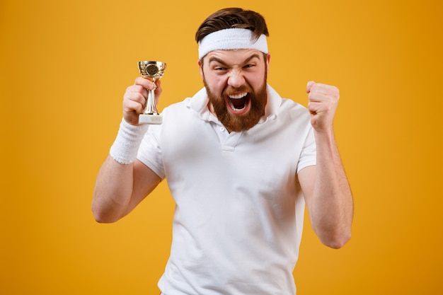 Foto gratuita emocional joven deportista con recompensa hacer gesto ganador.