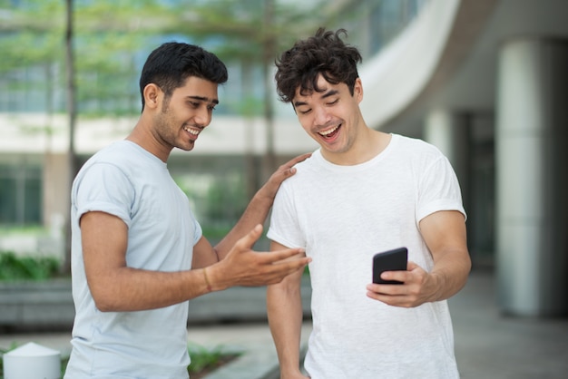 Emocionales amigos jóvenes discutiendo noticias impactadas