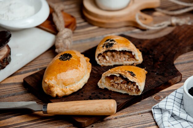 Empanadas de carne de masa de bougie en una tabla de madera