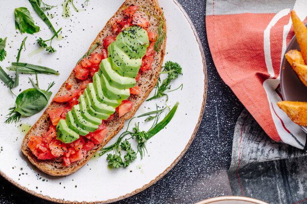 Emparedado de pan con tomates picados, pepinos y hierbas.