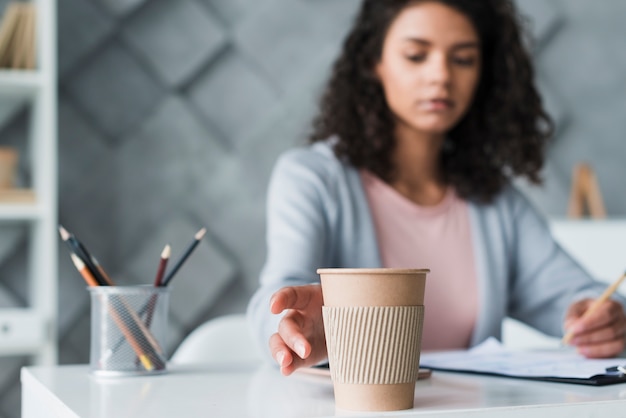 Foto gratuita empleada femenina étnica tirando de la mano a la taza