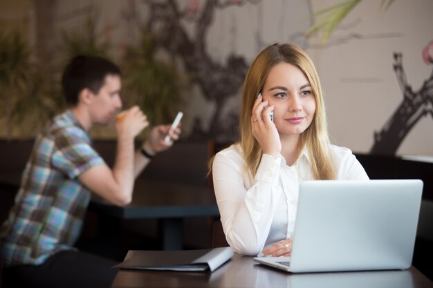 Empleada hablando por teléfono en la cafetería