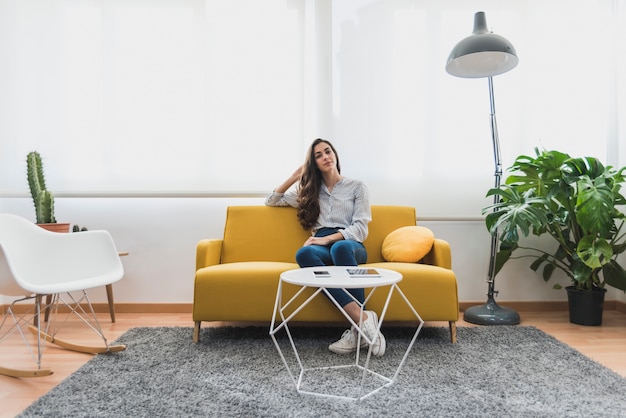 Foto gratuita empleada joven sentada en el sillón de la oficina