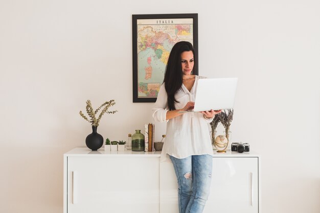 Empleada joven trabajando junto a un mueble blanco