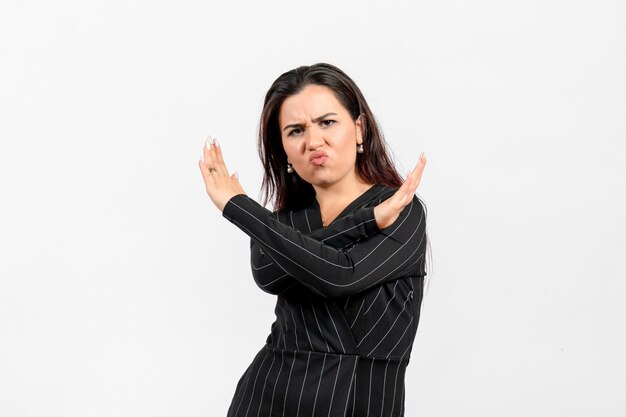 Empleada de oficina en estricto traje negro posando en blanco