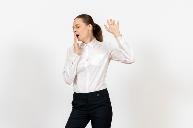 Empleada de oficina femenina en elegante blusa blanca bostezando en blanco