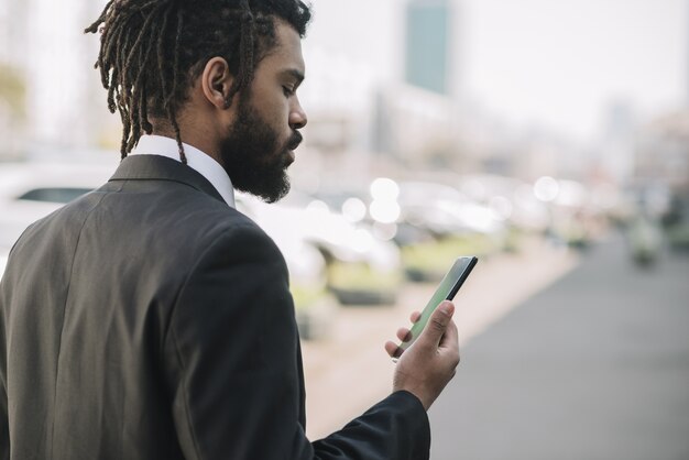 Empleado afroamericano mirando teléfono