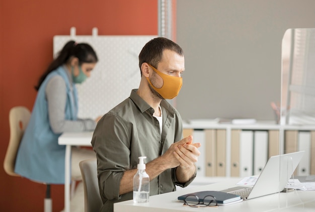 Empleado desinfectar las manos en el trabajo