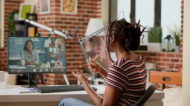 Empleado de la empresa que asiste a una reunión de negocios de videollamadas en una computadora con cámara web, hablando con colegas sobre el trabajo remoto. Uso de videoconferencia en línea y llamada de teleconferencia remota para chatear.