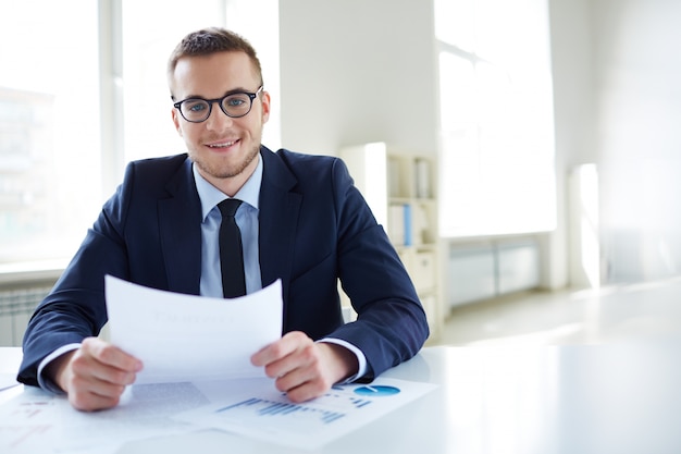 Empleado con gafas sosteniendo un informe