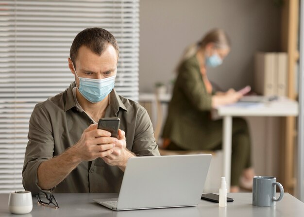 Empleado con mascarilla en la oficina