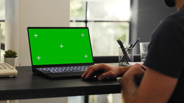 Foto gratuito el empleado masculino mira la pantalla verde
