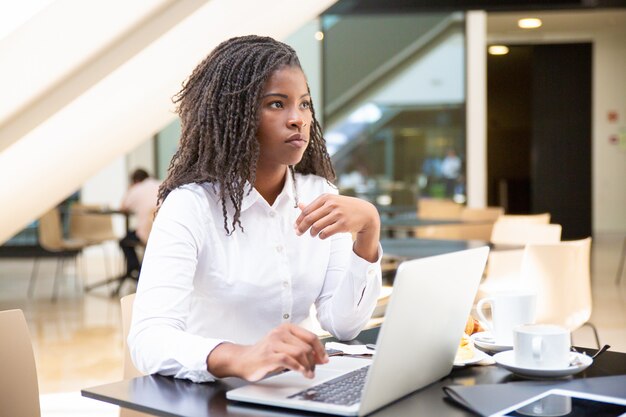 Empleado de oficina femenino serio que usa la computadora