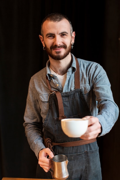 Empleado sonriente haciendo café