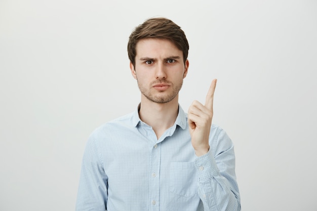 Empleador de sexo masculino decepcionado regañando al trabajador, agitando el dedo disgustado