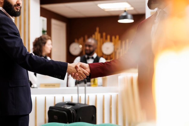 Foto gratuita empleados acordando una asociación, reunión internacional oficial exitosa en el hotel. emprendedores de negocios se dan la mano para iniciar una colaboración fructífera para el crecimiento de la empresa. de cerca.