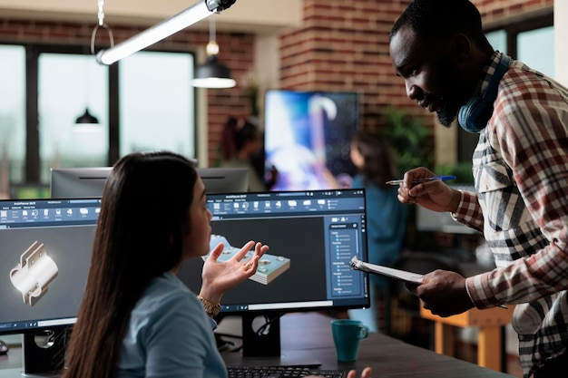 Empleados del departamento de producción que desarrollan tecnología gráfica avanzada utilizando software especializado. Artistas digitales creativos en 3D discutiendo sobre problemas de escena y mallas geométricas no optimizadas.