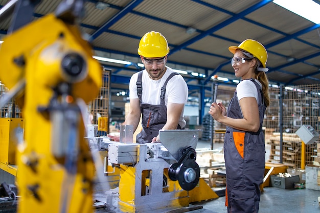 Empleados industriales que trabajan juntos en la línea de producción de la fábrica.