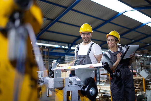 Empleados industriales que trabajan juntos en la línea de producción de la fábrica.