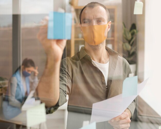 Empleados con máscaras faciales en la oficina.