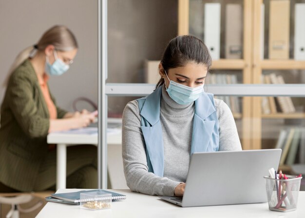 Foto gratuita empleados que trabajan con mascarillas