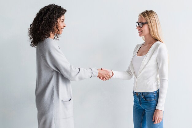 Empleados sonrientes multirraciales dándose la mano