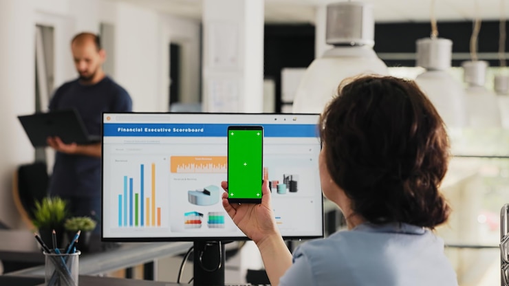 Photo Gratis employee uses phone app with greenscreen